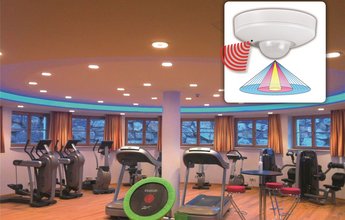 Salle de fitness avec lampes LED encastrées Züblin et détecteurs acoustiques.